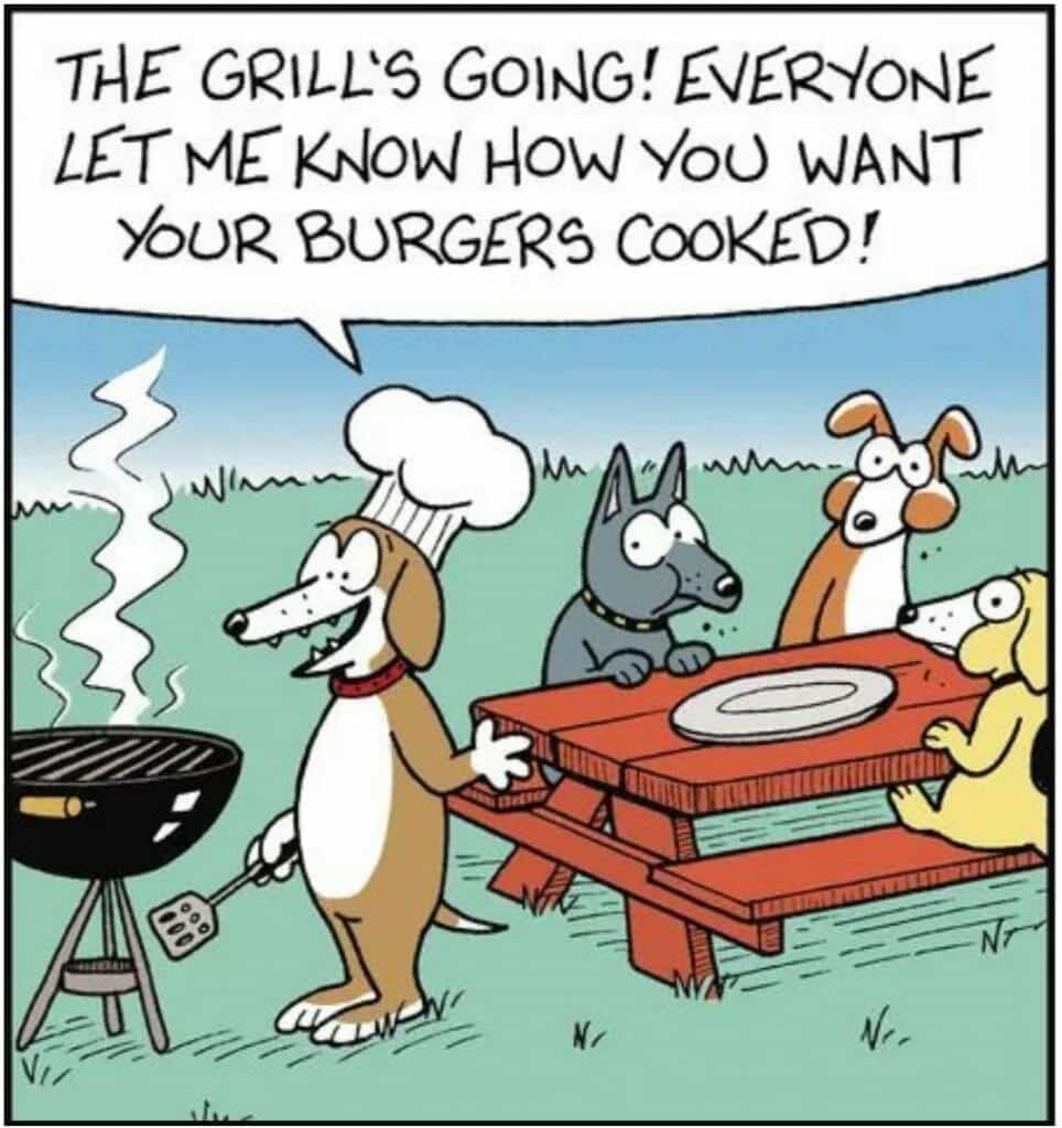 Four cartoon dogs gathered around a picnic table while one dog wearing a chef's hat grills on a barbecue outside.