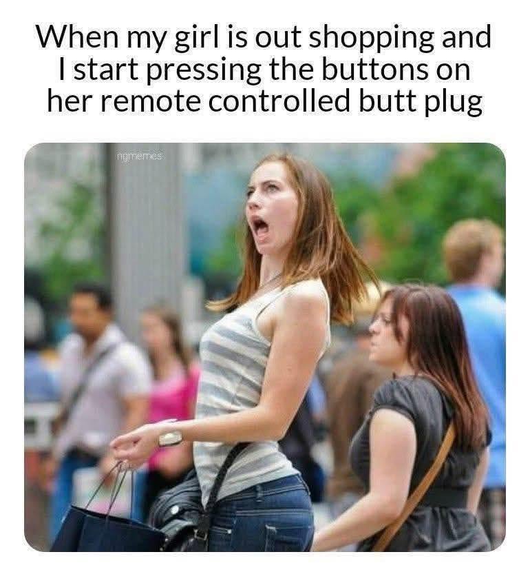 A woman outdoors makes a shocked and exaggerated facial expression while holding shopping bags, as other people walk around casually.