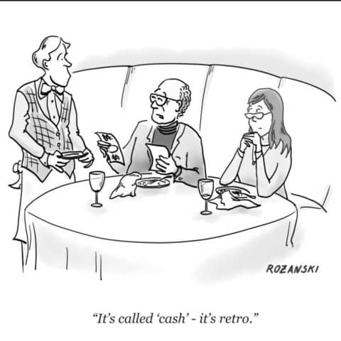A waiter talking to a man and woman sitting at a table in a restaurant, holding a check and explaining payment.