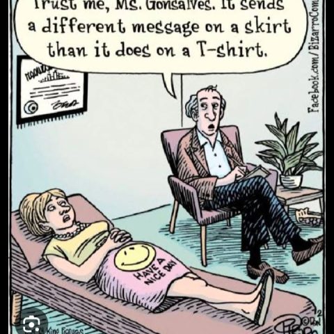 A woman lies on a therapy couch wearing a skirt with a smiley face and the words 'Have a nice day'. A male therapist in a chair talks to her.