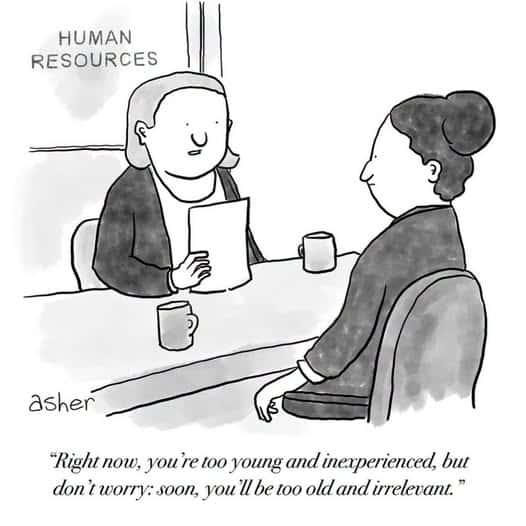 Two people sitting at a desk in a human resources office, one holding a paper and talking to the other.
