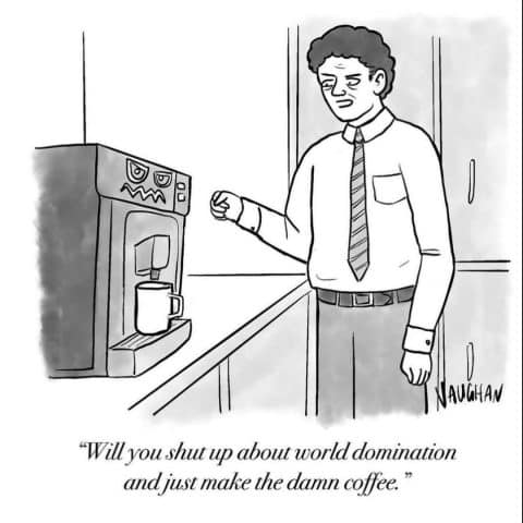 Man in office clothes standing in front of a coffee machine with an angry face, looking frustrated.